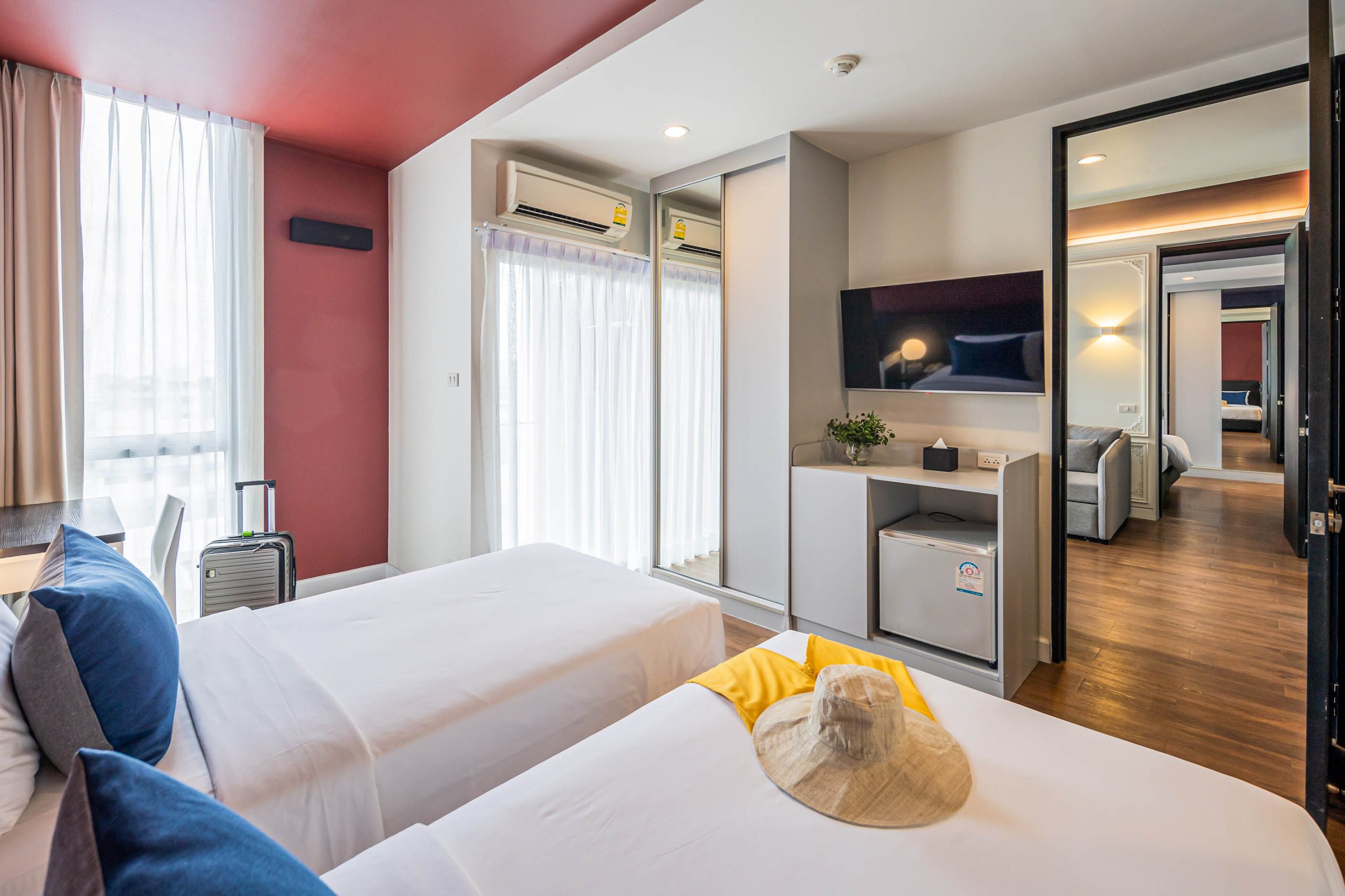 Spacious twin bed room with connected living area at Red Crocodile Hotel near BITEC
